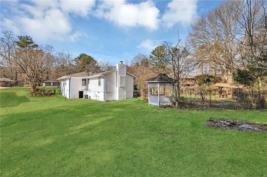 349 Virginia Place Southeast Marietta, GA 30067 - Photo 33 of 37 a view of a white house in front of a big yard with plants and large trees