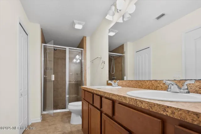 a bathroom with a granite countertop sink a toilet and a large mirror