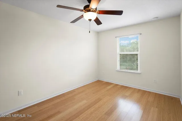 an empty room with a window and a fan