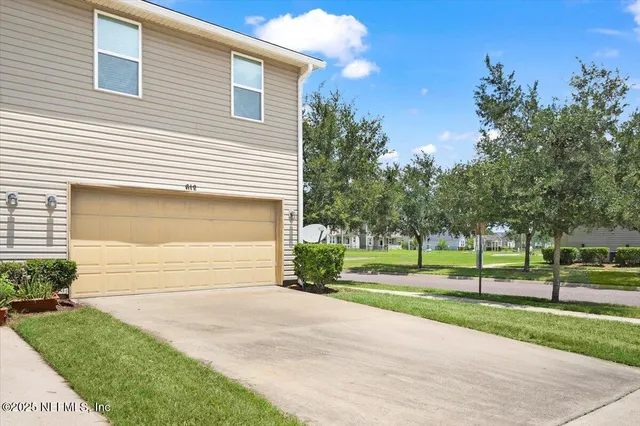 a front view of a house with a yard and trees