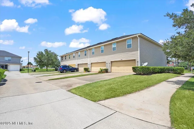 a front view of a house with a garden and trees
