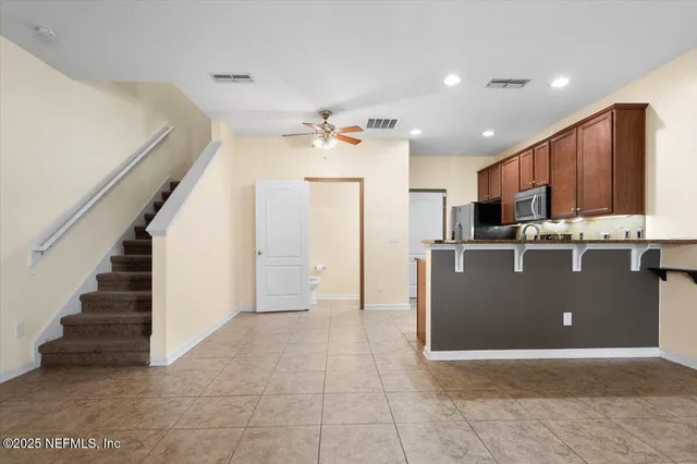 a view of a kitchen with stainless steel appliances granite countertop a refrigerator a stove and a sink