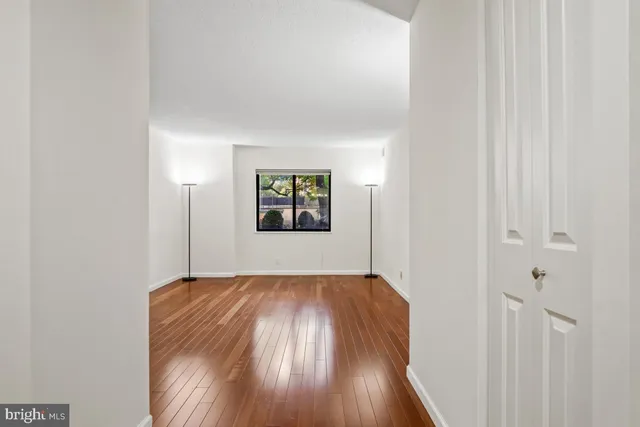 a view of empty room with wooden floor