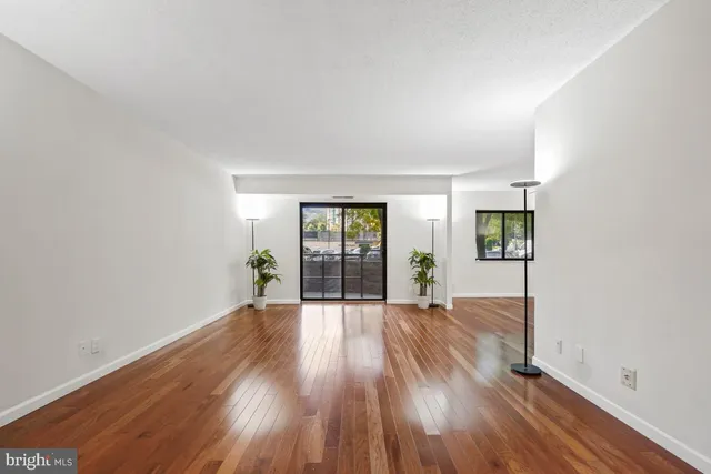 a view of empty room with wooden floor