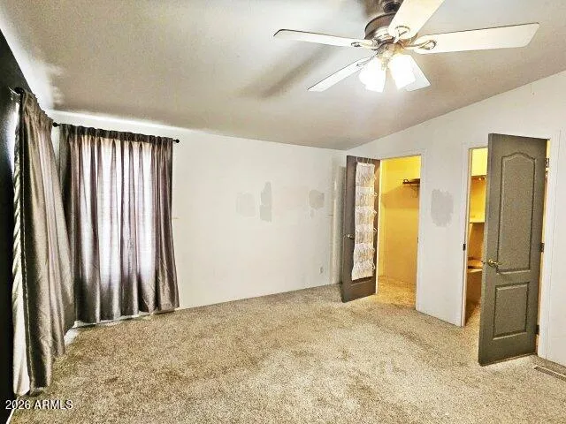 an empty room with closet and a ceiling fan
