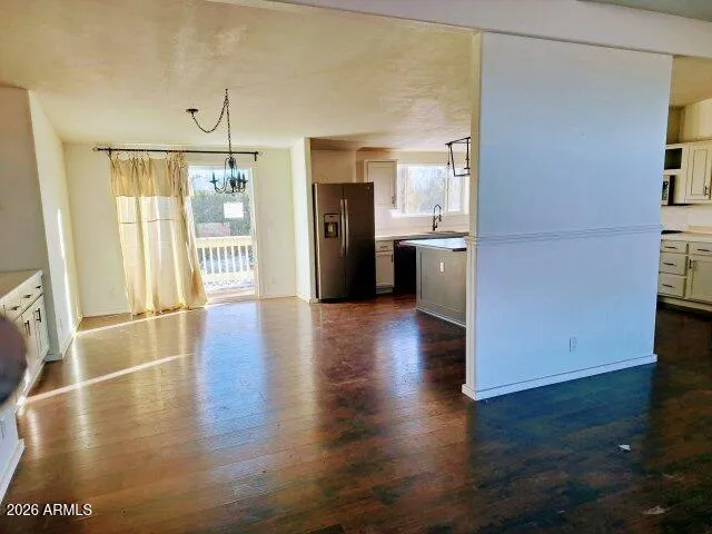 a view of a hallway with wooden floor and a kitchen