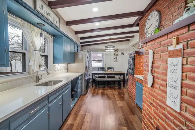 a kitchen with a sink and wooden floor