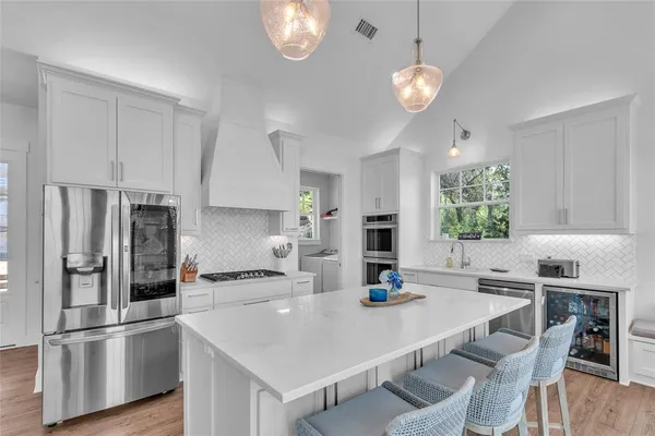 a kitchen with stainless steel appliances granite countertop a sink refrigerator and cabinets