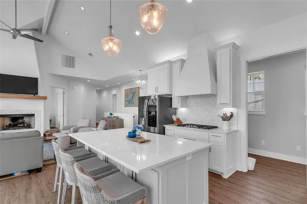 a kitchen with a dining table chairs and white cabinets