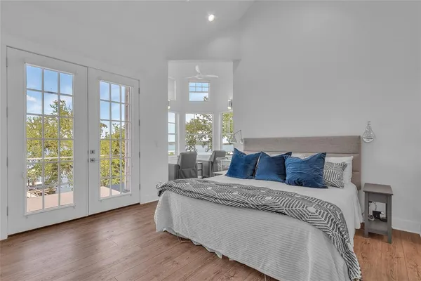 a large bedroom with a bed and wooden floor