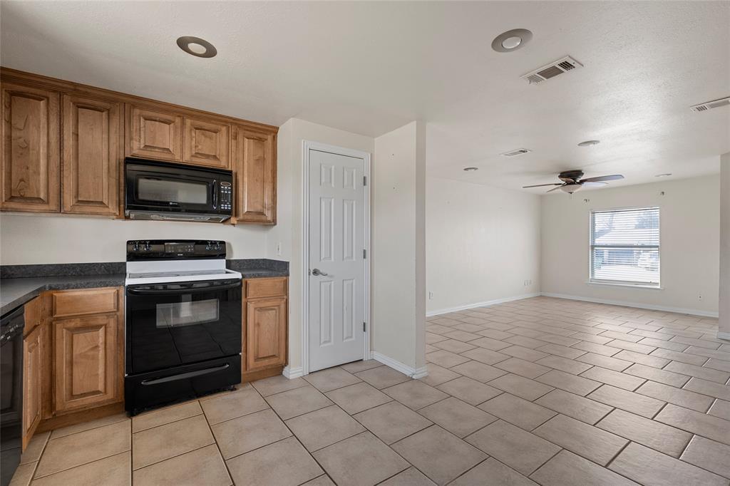 310 3rd Street Abbott, TX 76621 - Photo 7 of 23 a kitchen with granite countertop a stove a microwave and a sink