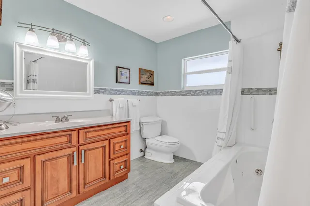 a spacious bathroom with a sink a toilet and a mirror