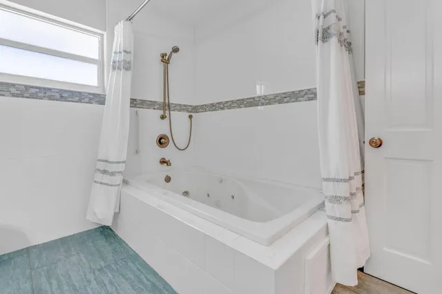 a bathroom with a bathtub and shower