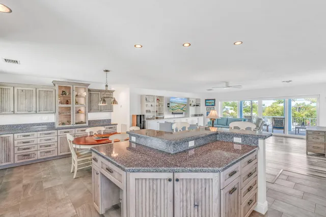 a kitchen with granite countertop a table and chairs in it