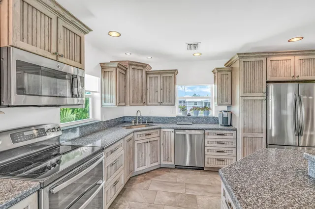 a kitchen with stainless steel appliances granite countertop a sink stove and refrigerator