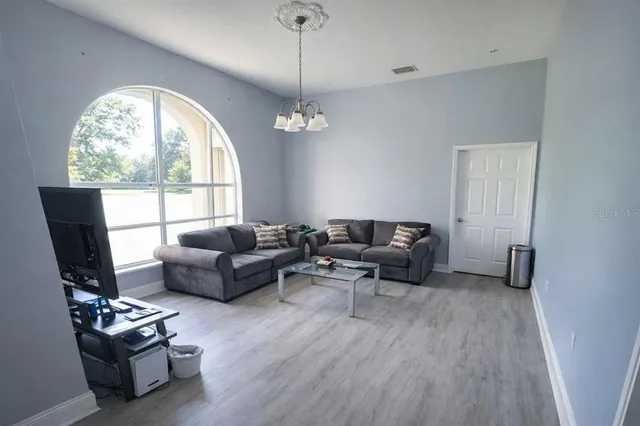 a living room with furniture a flat screen tv and a large window