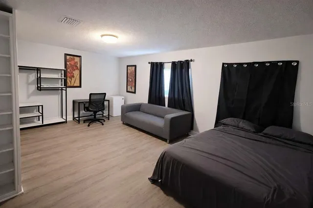 a bedroom with two bed and a desk