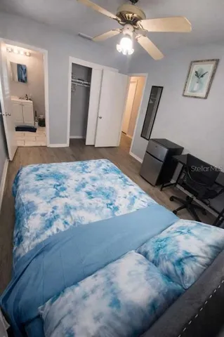 a bedroom with a bed and a mirror on the dresser