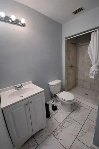 a bathroom with a toilet sink and shower