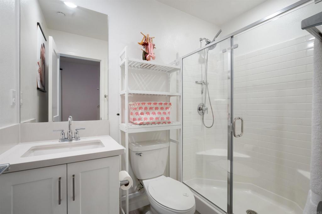 522 South Cleveland Street, Unit 7 Oceanside, CA 92054 - Photo 12 of 24 a bathroom with a shower sink vanity mirror and toilet