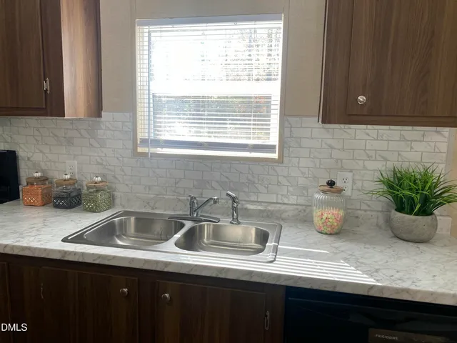 a kitchen with a sink dishwasher and a wooden cabinets