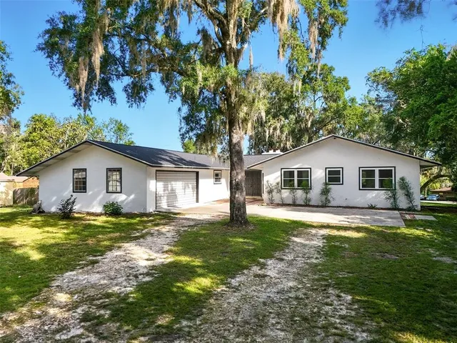 a front view of a house with yard and green space