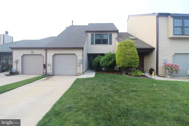 a front view of a house with a garden and garage