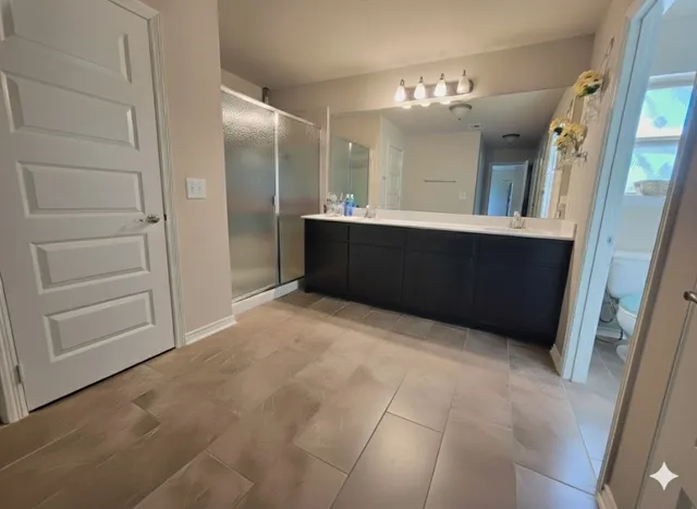 a large bathroom with a double vanity sink and mirror