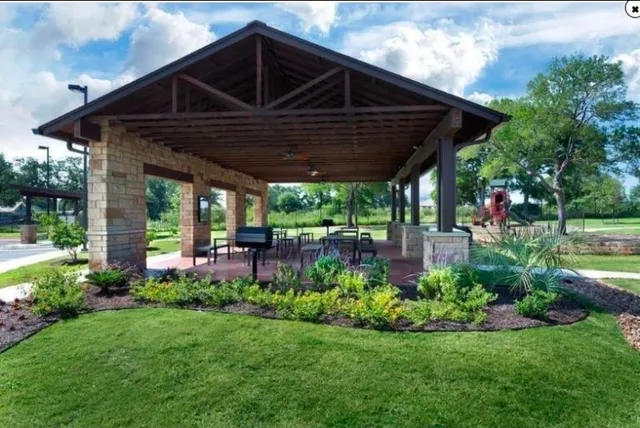 a patio with a table and chairs and potted plants