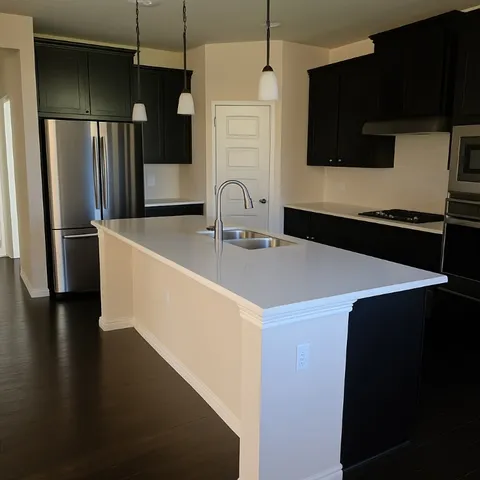 a kitchen with stainless steel appliances a refrigerator a sink a stove and microwave