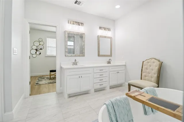 a spacious bathroom with a double vanity sink and a mirror