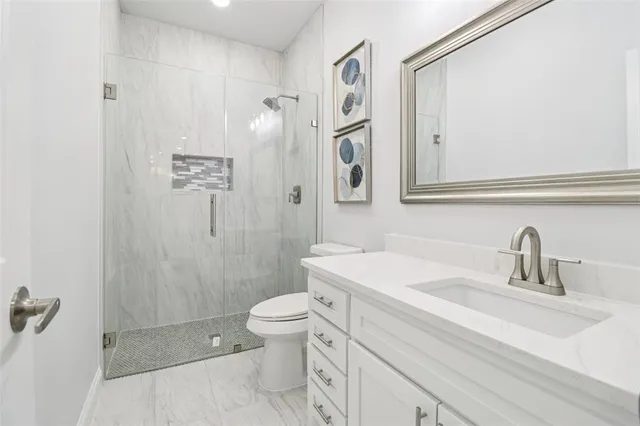 a bathroom with a sink a toilet and shower