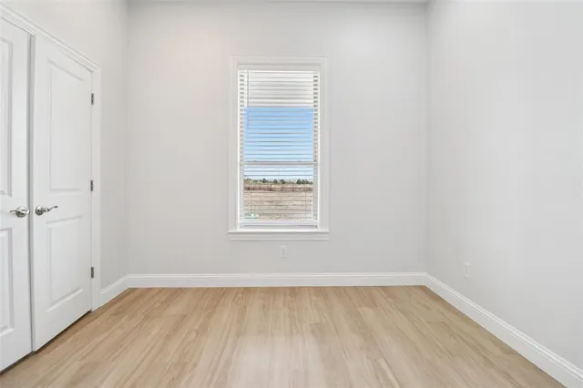 a view of a room that has wooden floor and white walls
