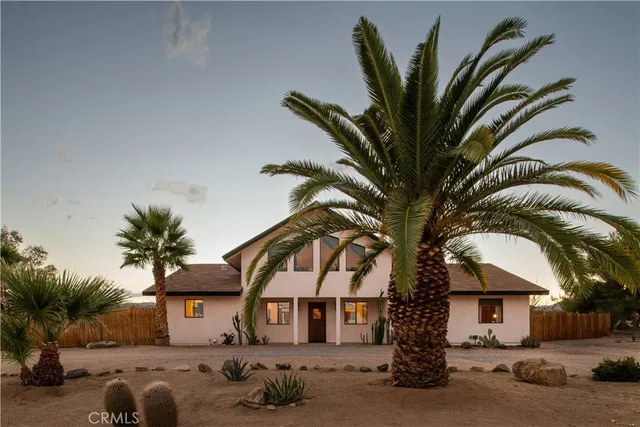 a front view of a house with a tree