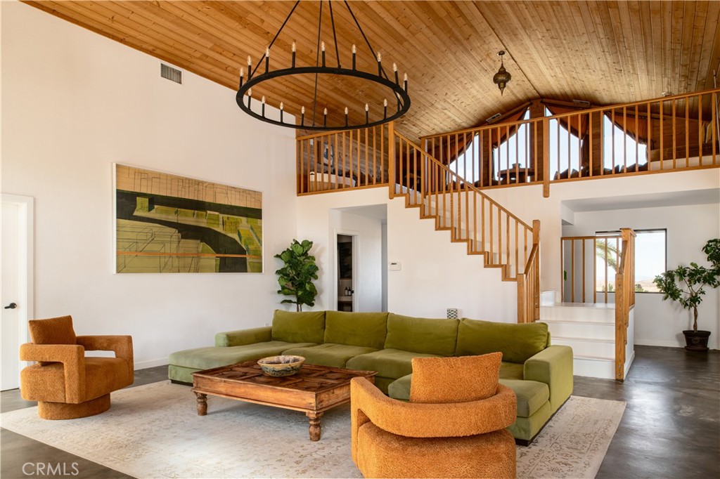 382 Cherokee Trail Yucca Valley, CA 92284 - Photo 9 of 33 a living room with furniture a chandelier and a dining table