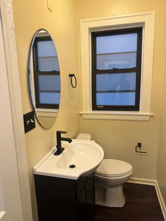 a bathroom with a toilet sink and mirror