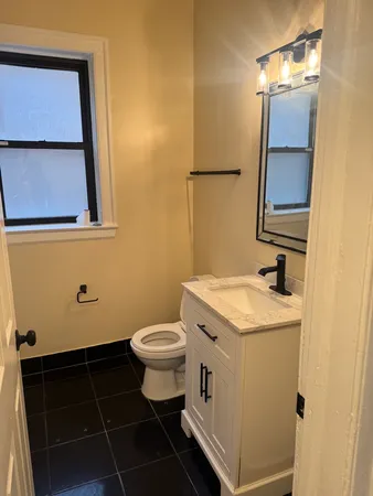 a bathroom with a sink toilet and mirror