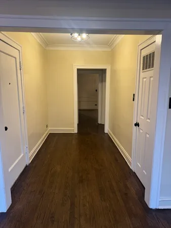a view of a hallway with wooden floor and closet