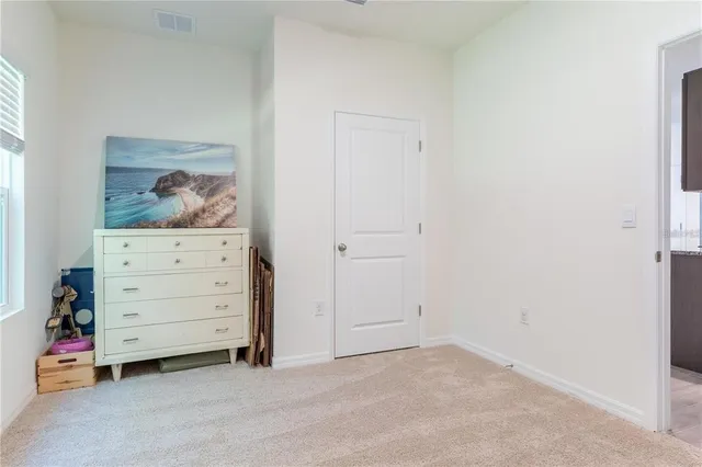 an empty room with a baby crib and dresser