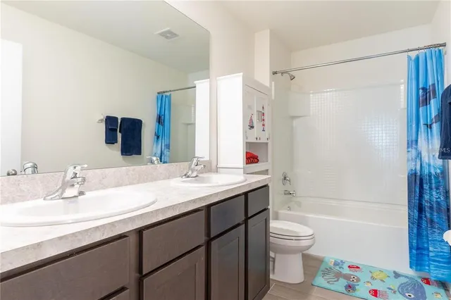 a bathroom with a sink a toilet and a large mirror