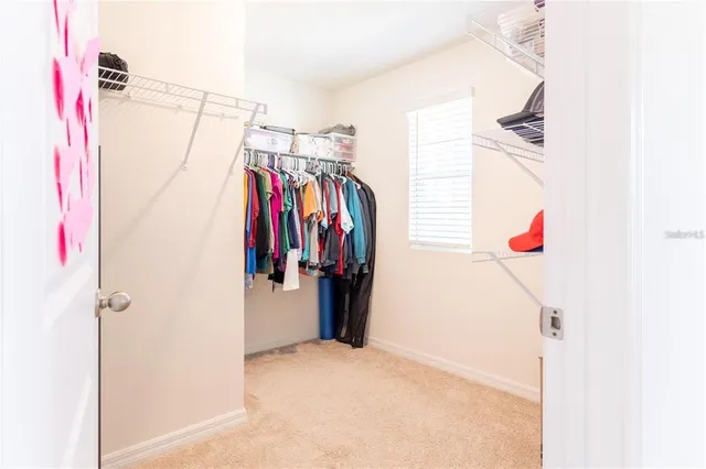 a view of walk in closet with clothes and shoes