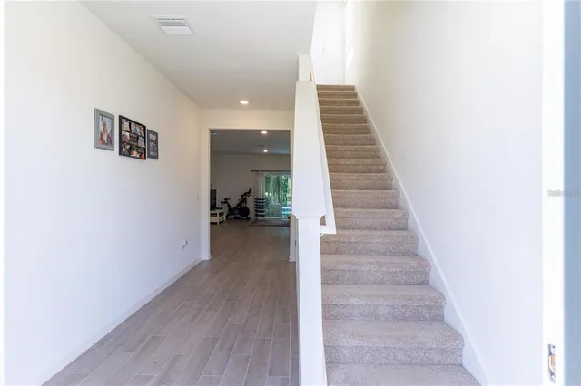 a view of a hallway with wooden floor and staircase