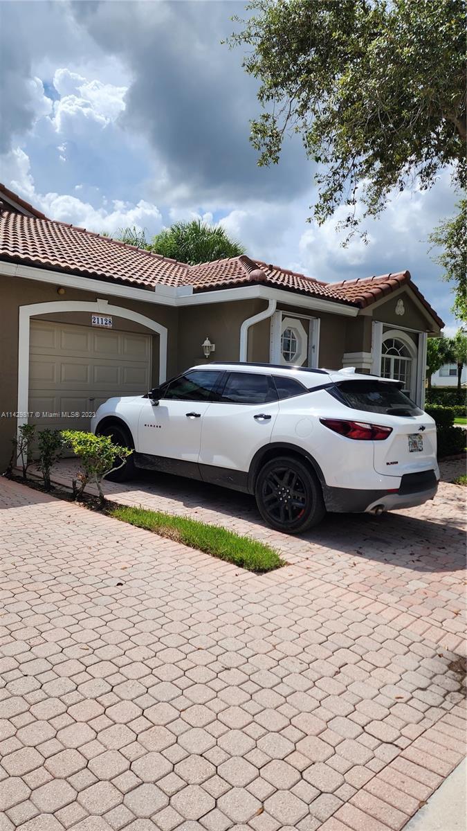 21128 Vía Solano Boca Raton, FL 33433 - Photo 2 of 25 a front view of a house with cars parked