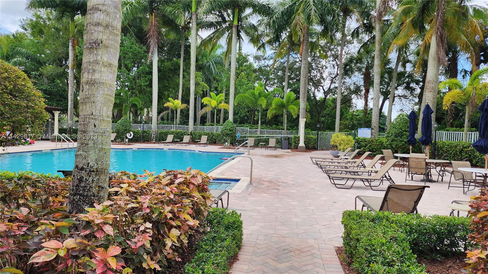 21128 Vía Solano Boca Raton, FL 33433 - Photo 3 of 25 a view of a lake with a bench and trees