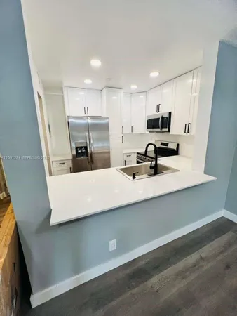 a kitchen with kitchen island a sink stainless steel appliances and cabinets