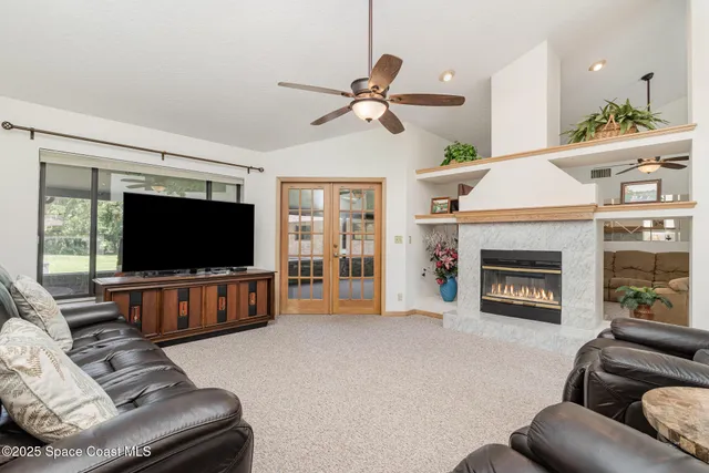 a living room with furniture a flat screen tv and a fireplace