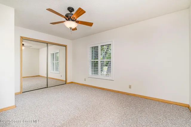an empty room with fan and windows