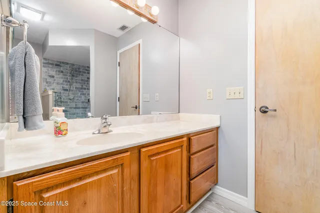 a bathroom with a granite countertop sink and a mirror