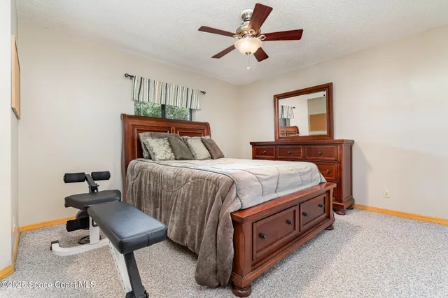 a spacious bedroom with a bed and a chandelier