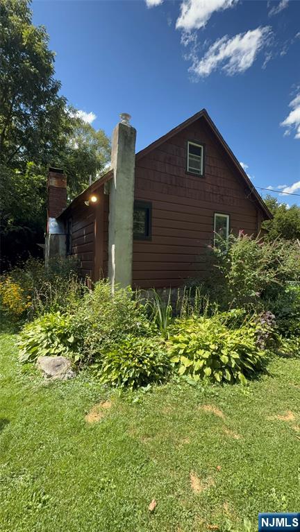 78 Woodland Road Ringwood, NJ 07456 - Photo 22 of 33 a brick house with lots of plants in front of it